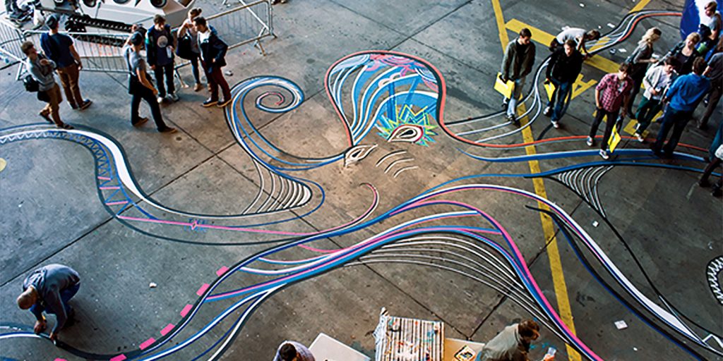 A large tape art mural of an octopus on the floor of a festival in Berlin