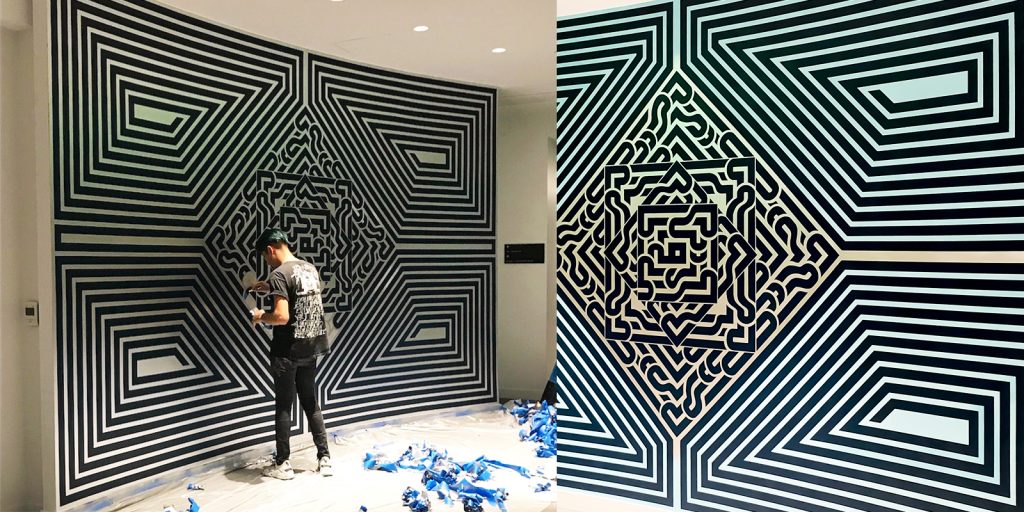 Flekz has been creating art for over 15 years. Here we see him working on a large scale geometric tape mural on a curved wall using black tape.