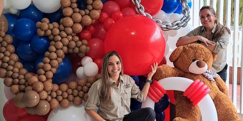 Globos Manas posing with a teddy bear balloon arrangement