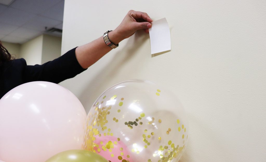 Sticking a UGlu® Power Patch to a wall to hold up balloons